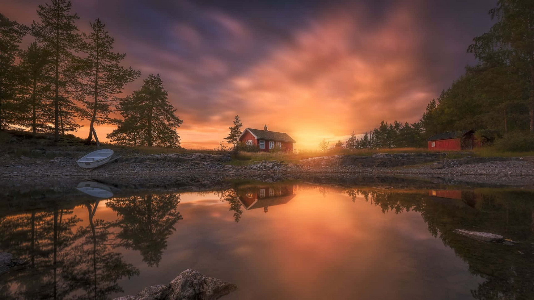 Download A House Is Reflected In The Water At Sunset Wallpaper